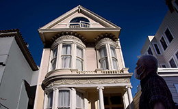 man admiring a victorian home