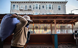 pedestrian walking by an outdoor dining setup