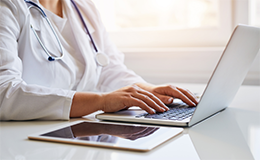 medical professional using a laptop