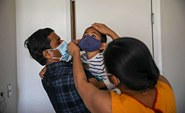 Dipali Suryamanshi and Rahul Suryawanshi put a mask on their son